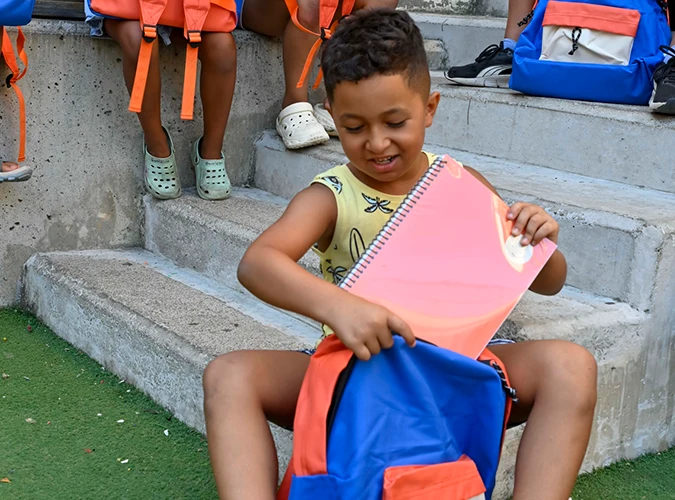 Un menino beneficiário do programa CaixaProinfància com material escolar novo © Fundação ”la Caixa”